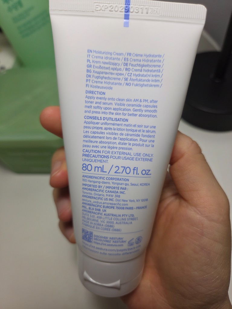 Back of an AESTURA ATOBARRIER365 Cream tube held in hand, showing directions and 80 mL packaging details