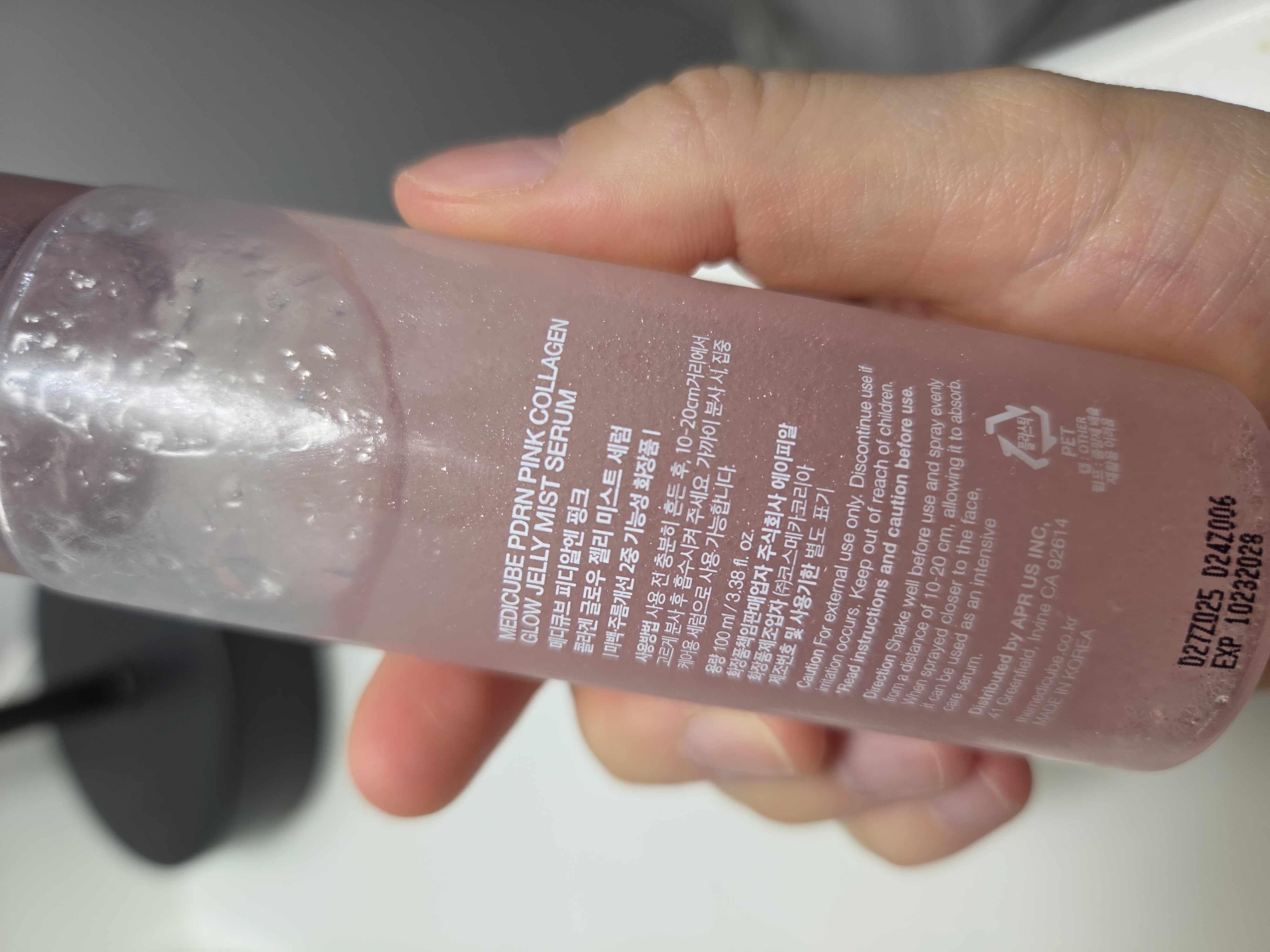 Back label of the medicube PDRN Pink Collagen Glow Jelly Mist Serum bottle held in hand