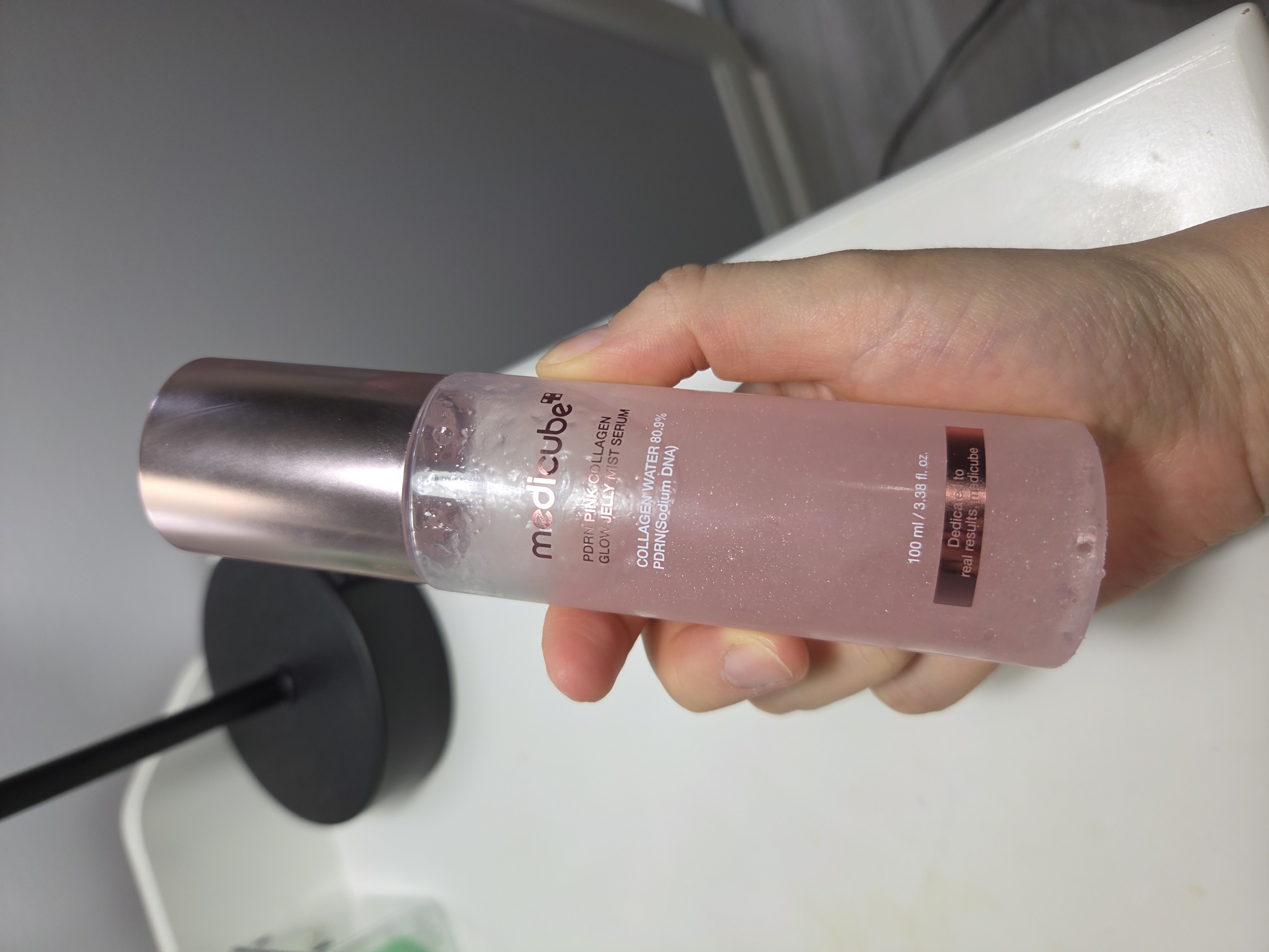 Front of the medicube PDRN Pink Collagen Glow Jelly Mist Serum bottle held in hand