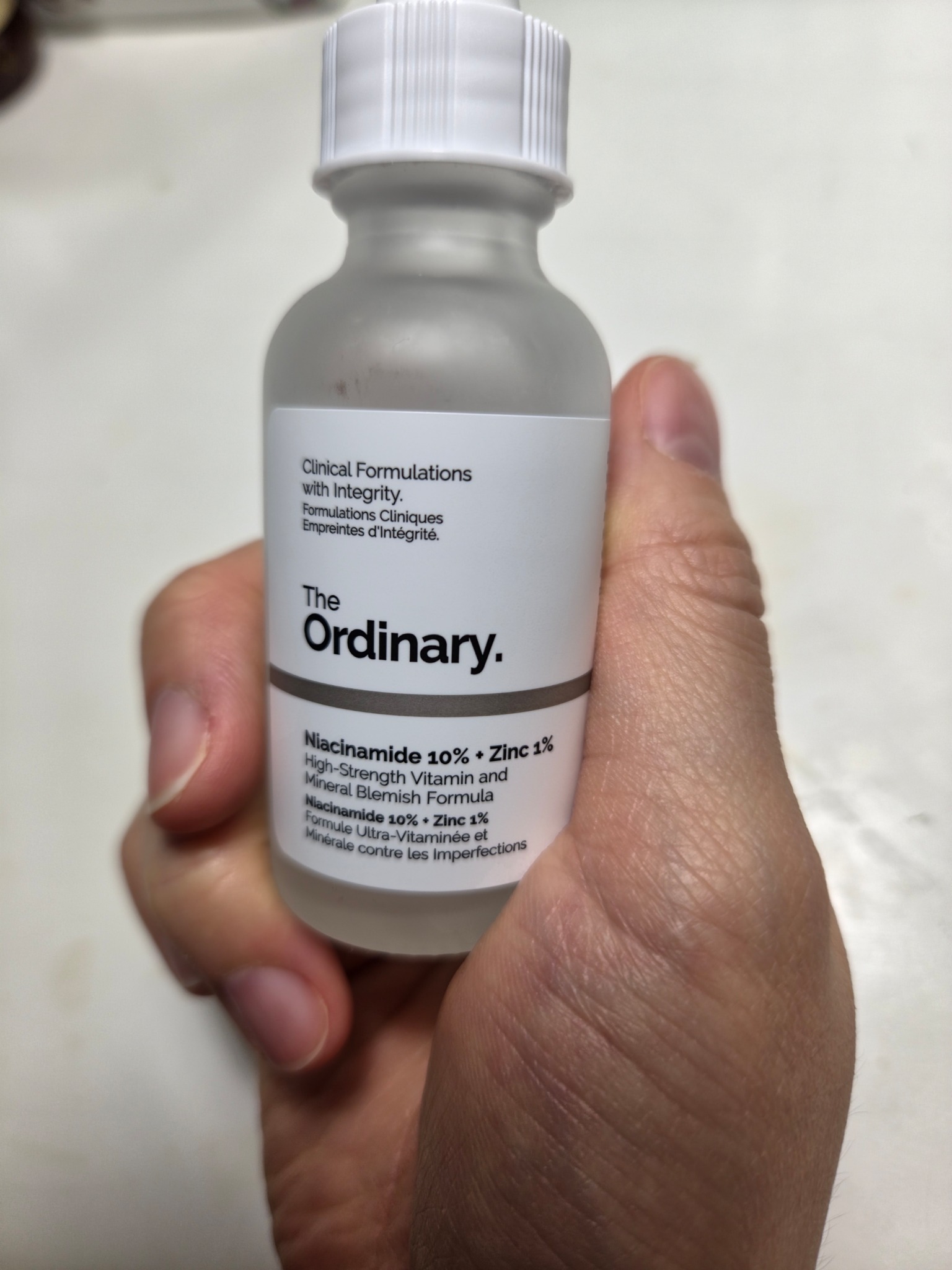 Front of The Ordinary Niacinamide 10% + Zinc 1% bottle held in hand, showing the dropper and label